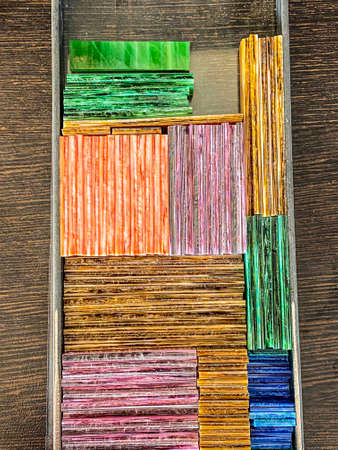 Colorful pieces of stained glass stack in a box