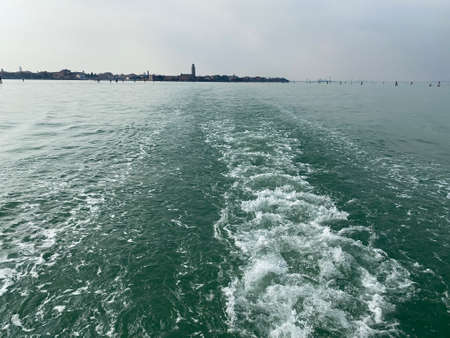 The lagoon view from a boat taxi leaving behind it Veniceの写真素材