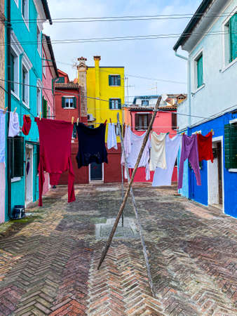Laundry put to dry on a small traditional and very colorful place on the island of Buranoの写真素材