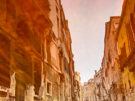 Reflection of the houses on the Varnished wooden hood, pontoon, of the water taxi in the streets of Venice, which leavesの写真素材