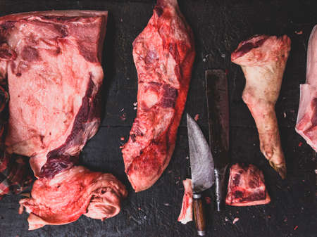 meat raw assortment and knife on the butcher's dark wooden working table. Top view.の写真素材