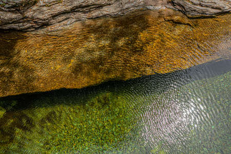Top view of the water of a river and a rock bank. The wind gives the whole a superb texture. On the...