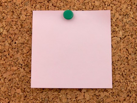 Close up of a pink postit on cork backgroundの写真素材