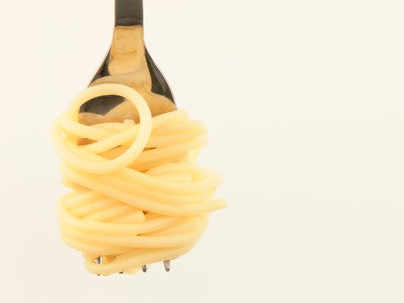 Close up of spaghetti rolled up on a forkの写真素材