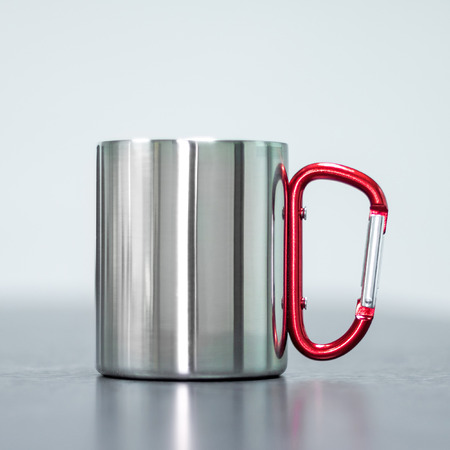 Stainless mug on table. Tin cup and handle clip for your design.の写真素材