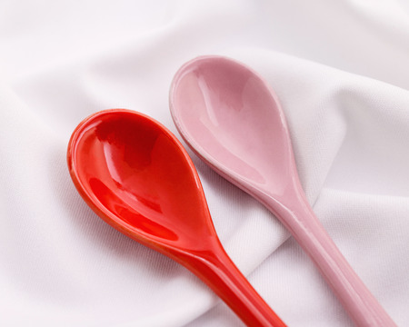 Lover ceramic spoons on white fabric background. Valentines concept.の写真素材