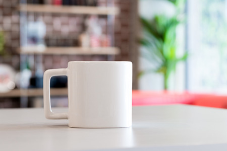 White mug in morning time at office room background. Blank drink cup for your design. Square shape.の写真素材