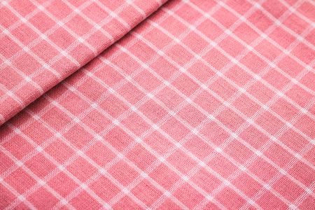 Closeup of pink tablecloth background. Detail of fabric in picnic pattern.