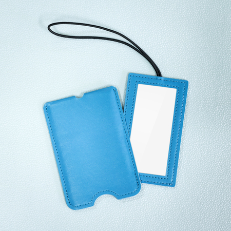 Blue leather hanging tag on synthetic background. Blank name tag for your design.の写真素材