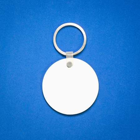White key ring on blue background. Key chain for your design. Hanging accessory or souvenir. ( Circle shape )の写真素材