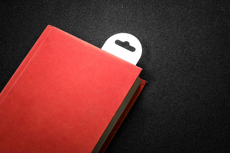 Vintage red book with a bookmark on dark background.の写真素材