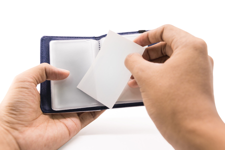A hand businessman put white card or name contact into blue leather wallet on isolated background.の写真素材