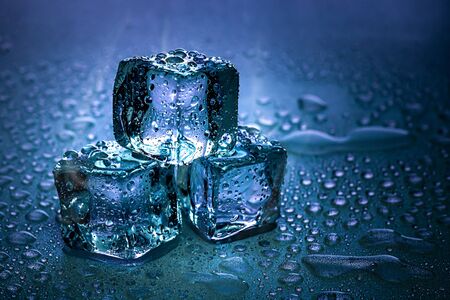 Ice cubes and water melt on cool background. Ice blocks with cold drinks or beverage.の写真素材