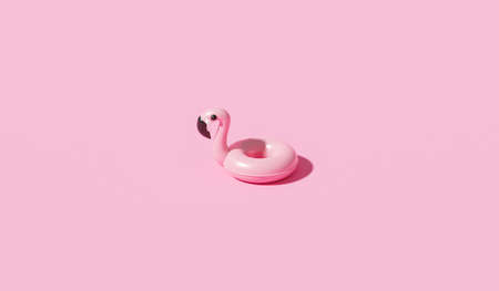 Minimal flamingo inflatable swimming pool ring and summer season on pink background with tropical holiday concept. 3D rendering.の写真素材