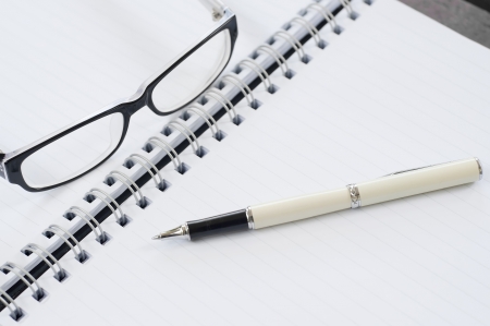 Notebook pen and glasses の写真素材