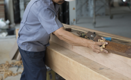 Carpenter using plane tool in workshop.の写真素材