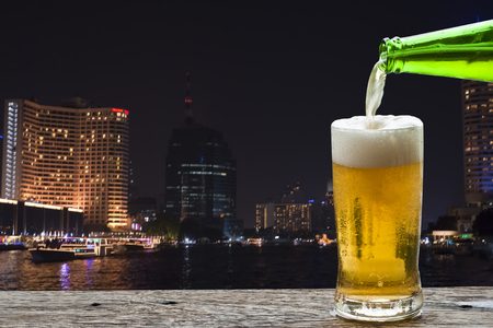 Enjoy beer with night landscape on Chao Phraya River, Bangkok Thailand.の写真素材