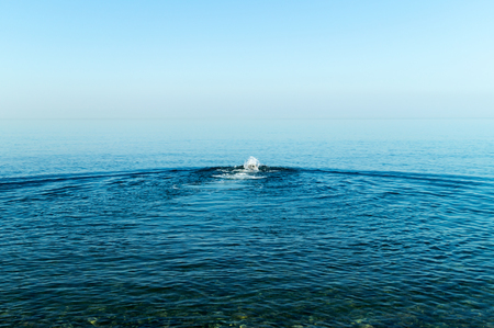 A splash of water in the sea from a floating man.の写真素材