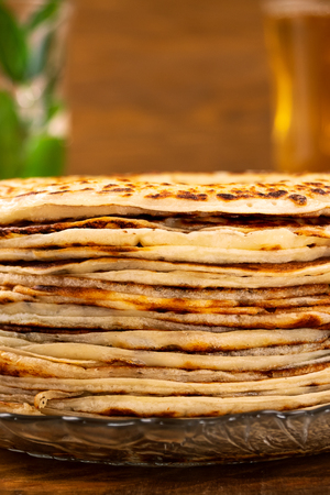 A stack of homemade pancakes on a plate, wooden background, close-up.の写真素材