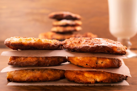 Homemade round biscuits with cottage cheese, stacked on top of each other on a wooden background,...
