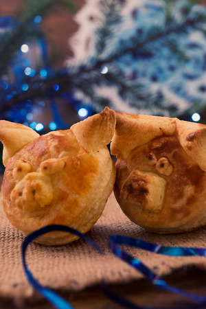 Two funny puff pastry pigs next to Christmas decorations, vertical frame.の写真素材