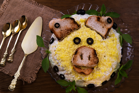Cold appetizer to the Christmas table to meet the pig year, Cutlery, linen napkin, wooden background.の写真素材