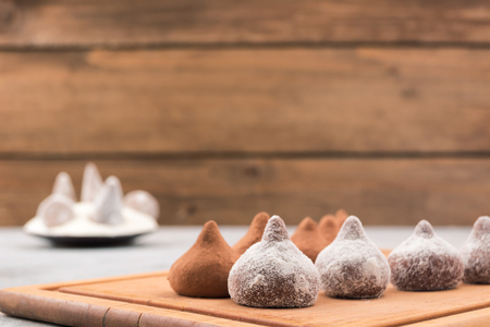 Chocolate truffles covered with powdered sugar and cocoa powder, wooden background, copy space.の写真素材