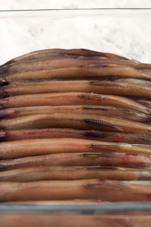 Fresh fish, tightly stacked up back in a glass bowl.