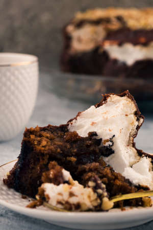 Leftover chocolate dessert after dinner. Vertical. Light background. White cream with brown dough.