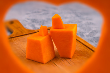 Stylized human figures carved from a pumpkin. Frame in the shape of a heart. The symbol of mutual love.の写真素材
