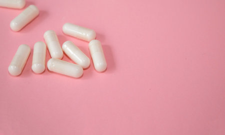 White capsules on a pink background with copy space. Top view.の写真素材
