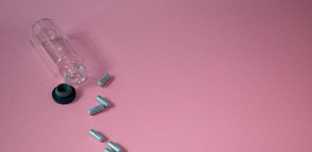 Pills and ampoules on a pink background. Selective focus.