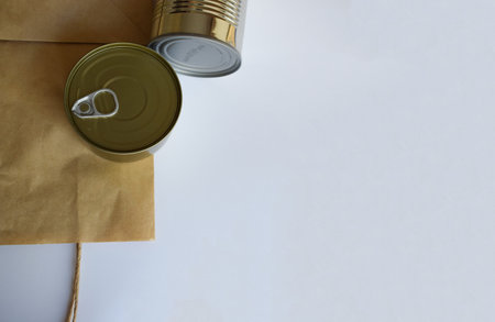 Tin can and brown paper envelope on white background. Copy space.の写真素材