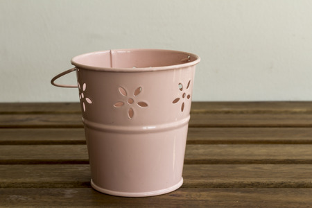 pink metal bucket on a wooden tableの写真素材