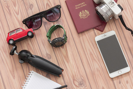 KUALA LUMPUR, MALAYSIA - JUNE 22, 2016 : Tripod, camera, toy car, sanglass, watch, handphone and note book. Travel Concept.のeditorial素材