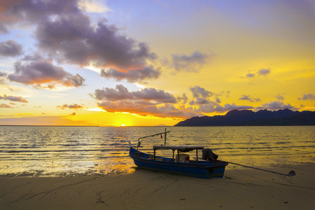 sunset on the beach and saw a fishing boat on the coastの写真素材