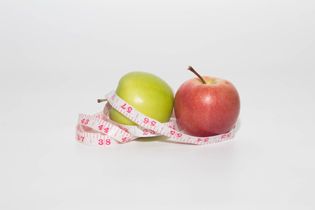 apple with measuring tape on white backgroundの写真素材