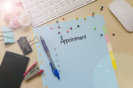 Business concept - View from the top of the table notebook, keyboard, mouse and phone for writing appointment.の写真素材