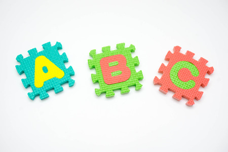 Colorful foam puzzle with word on a white background.