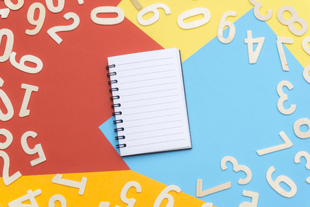 note book and scattered numbers on colorful paperの写真素材