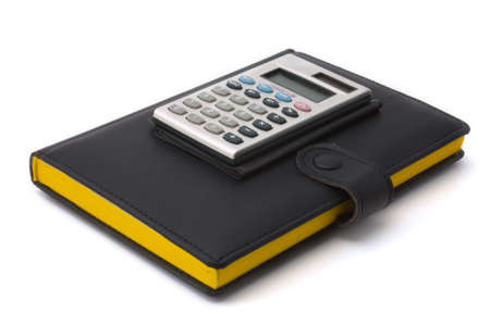 Calculator on a diary. The diary in black leather cover with bright yellow pagesの写真素材