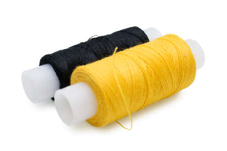 Two coils of yellow and black threads for sewing on a white background
の写真素材