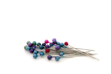 a handful of colored pins isolated on white background