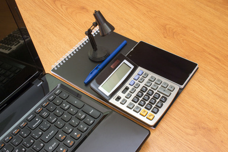 calculator notebook laptop and phone on the tableの写真素材