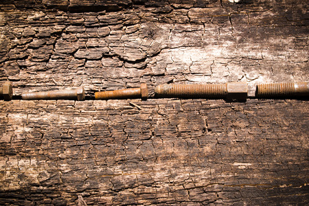 iron bolt rusty tools on an old wooden table closeupの写真素材
