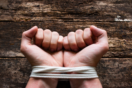 man with his hands tied demonstrates that he is a slaveの写真素材