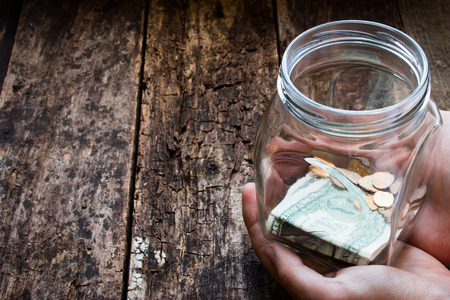 man holding a glass jar for donations