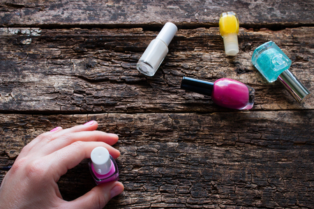 young woman holding a nail polishの写真素材