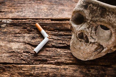broken cigarette and ashtray in the form of the skull - smoking kills conceptの写真素材