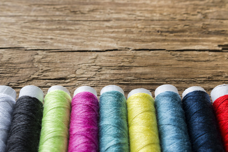 colored thread on a wooden background